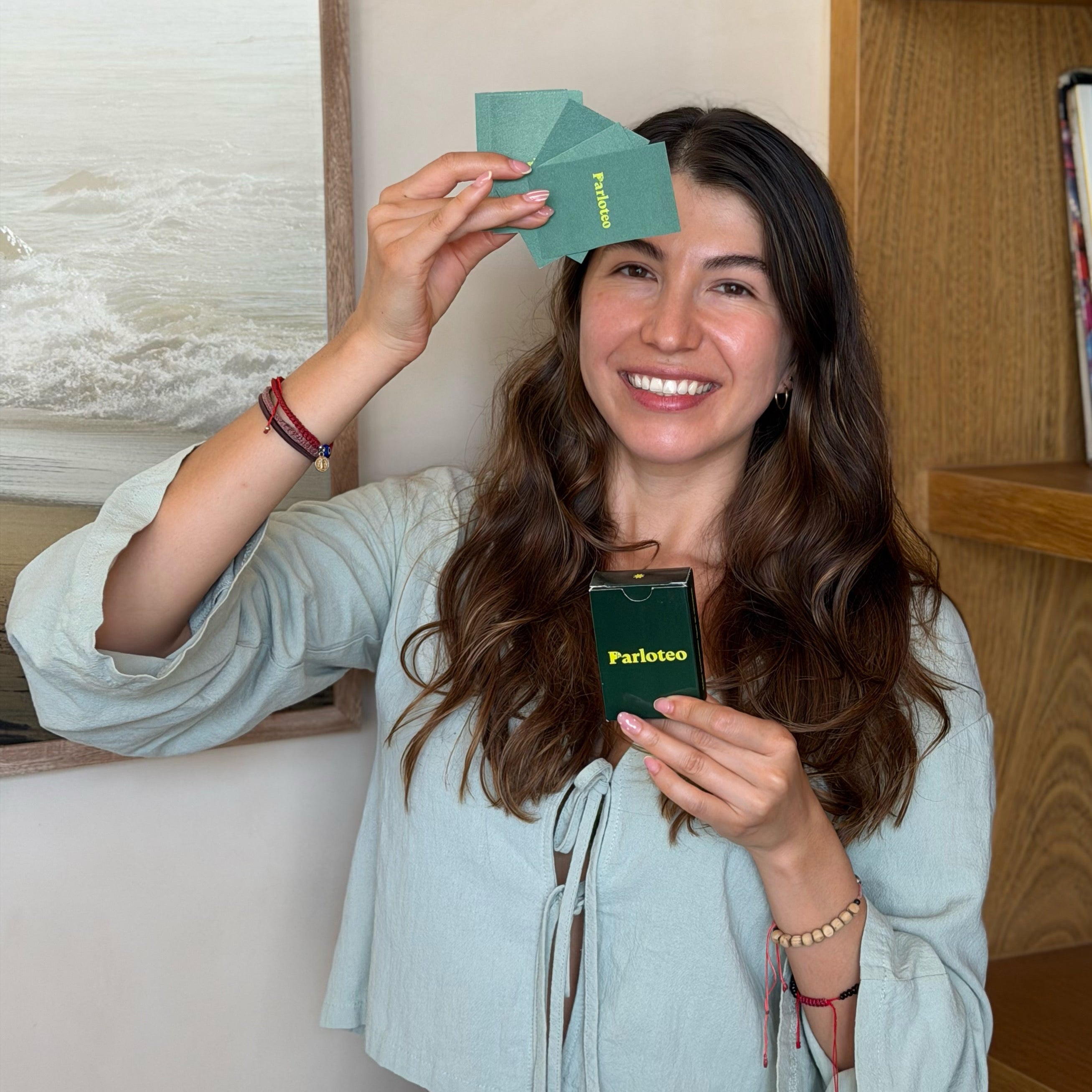 Mujer sonriendo con la caja y las cartas de Parloteo